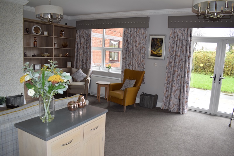 armchairs next to the window in the lounge and flowers on the table